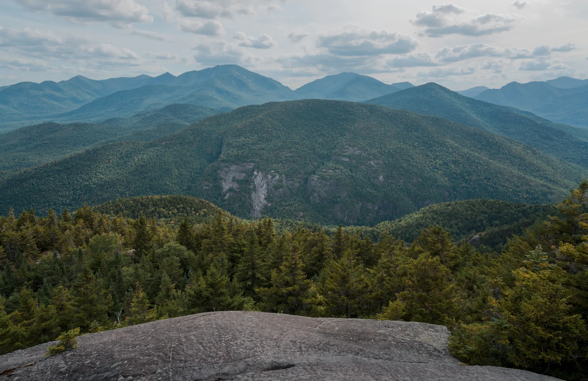 The Adirondack High Peaks under cloud, forested slopes below a bare granite summit